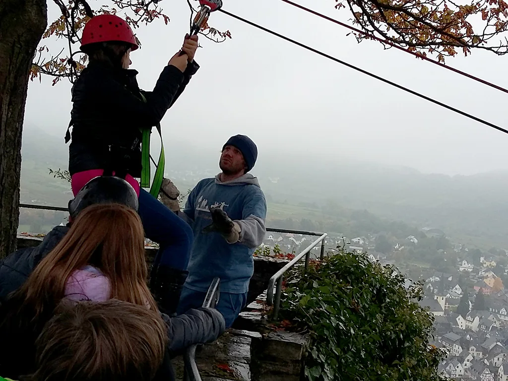 Person mit rotem Helm startet in die Seilrutsche.